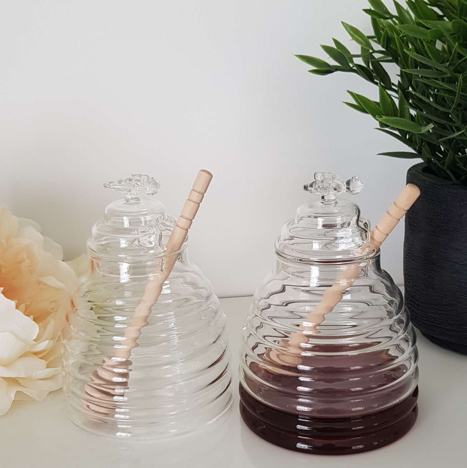 Glass honey jar with wooden stirrer
