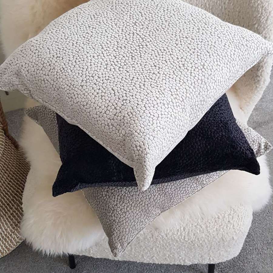 Textured cream cushion with velvet dot design